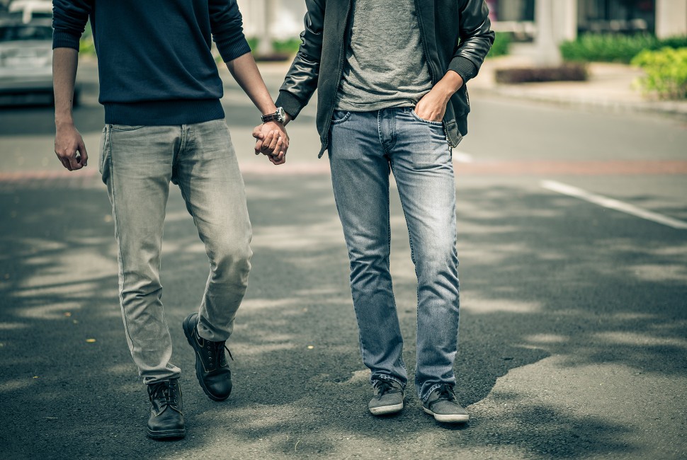 Two men holding hands and walking