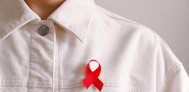 corduroy jacket with red HIV/AIDS ribbon pinned on