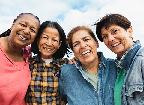 Four women hugging and smiling